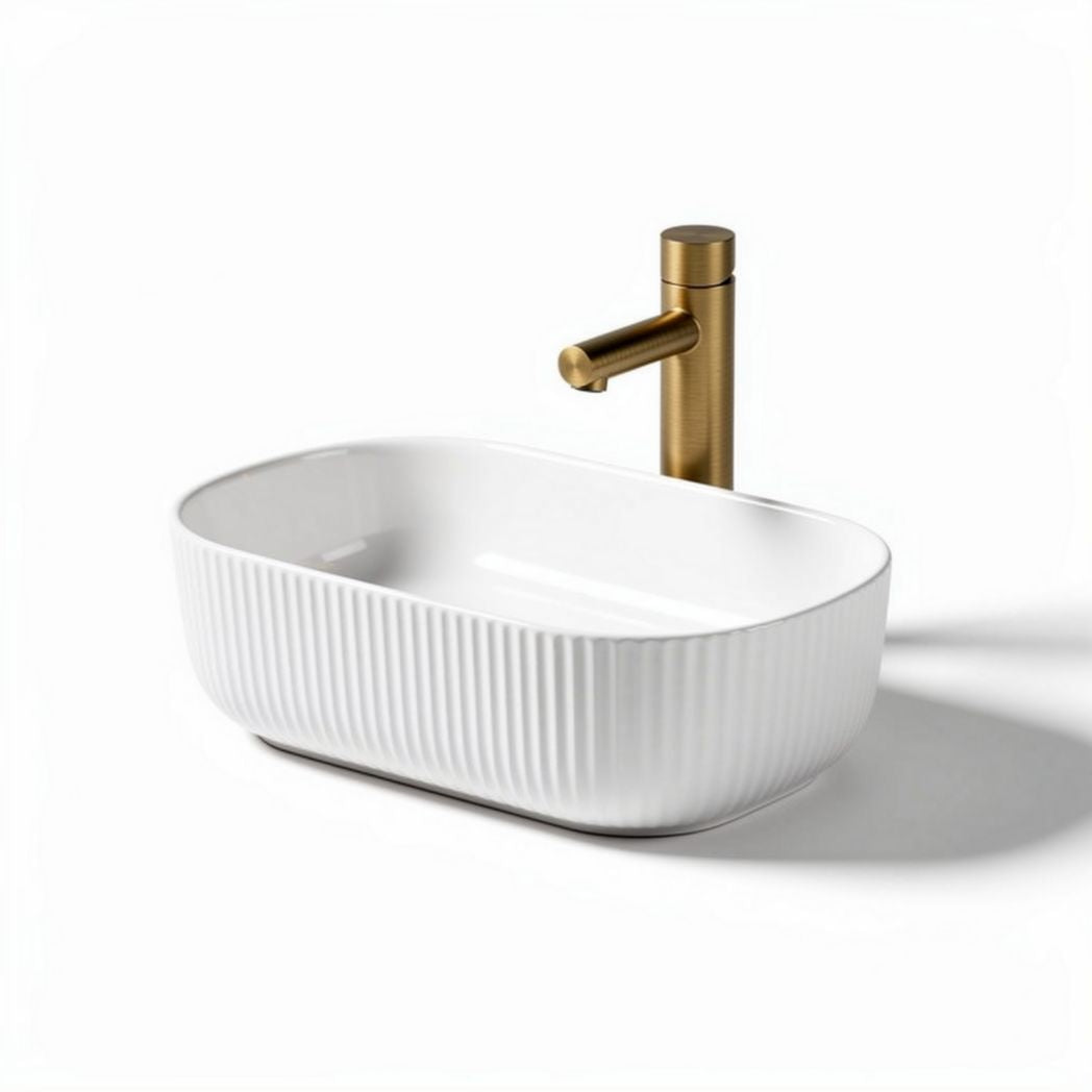 White ceramic oval sink with ribbed design and gold faucet 40 x 25 x 10cm